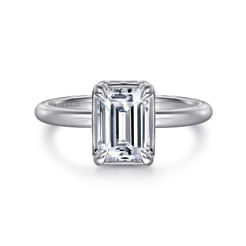Simple from above with elegant details in profile, this emerald cut engagement ring evokes the beauty of the Victorian era. Crafted in 14K white gold, it features a hidden halo surrounding the center stone. Refined milgrain detailing is evident throughout the halo, basket, and along the inner shank of this 0.14ct setting.