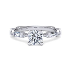 This Art Deco-inspired ring, crafted from 14K white gold, features a band of alternating round and baguette diamonds that catch the light with every movement. At its center, a stunning 1-carat round diamond is set to showcase its sharp lines and brilliance. The geometric design and sparkling stones create a perfect blend of vintage glamour and modern elegance.