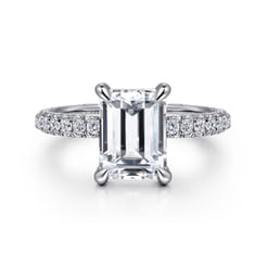 Radiant pavé diamonds blanket the surfaces of this sumptuous 18K white gold engagement ring. Set along three sides of the band as well as the basket beneath the 3ct center stone, 1.22cts of accent diamonds will leave her breathless. Attention to detail elevates this classic emerald cut engagement ring.