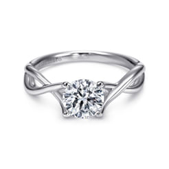 This understated engagement ring setting offers a modern twist on the iconic solitaire style. The 14K white gold band is delicately crafted into a regal twist that ascends to embrace your 1ct round center stone in a four prong setting.