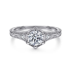 Intricate chevron engraving and sophisticated milgrain borders enhance this vintage-inspired engagement ring. Framed by a polished 14k white gold hexagon and shimmering .06ct accent diamonds, your round center stone is displayed to its best advantage.